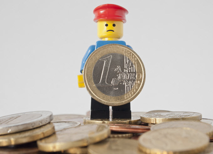 LEGO Man Holding a Euro Coin.